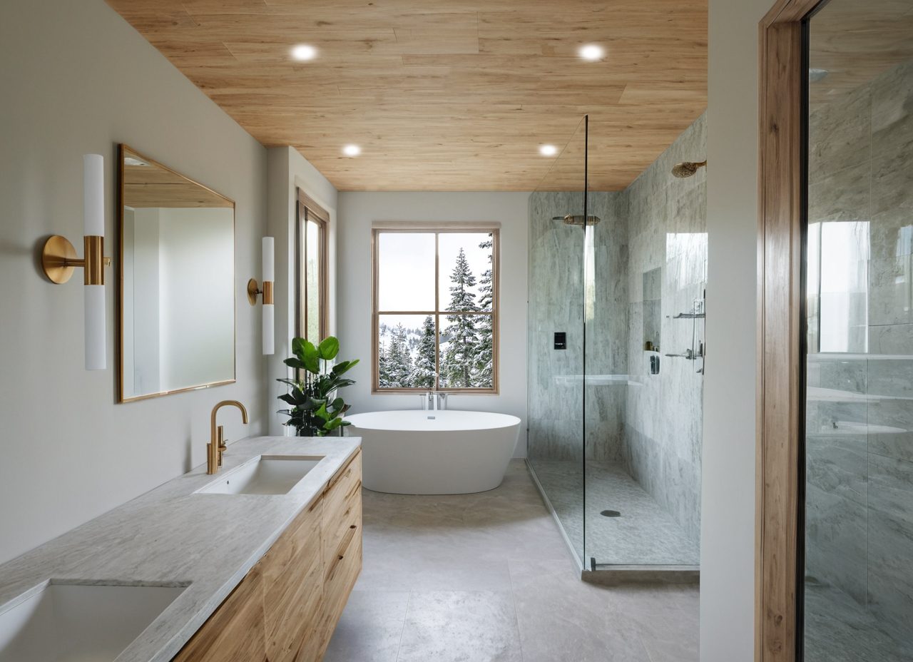 Primary bathroom with a wood plank ceiling, a floating oak vanity, brass fixtures, a freestanding tub and a glass-enclosed stone shower