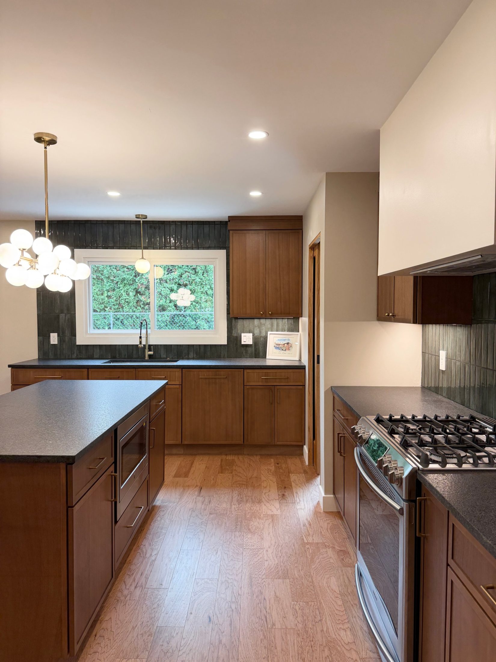 Renovated kitchen looking toward the sink, with a gas range and island