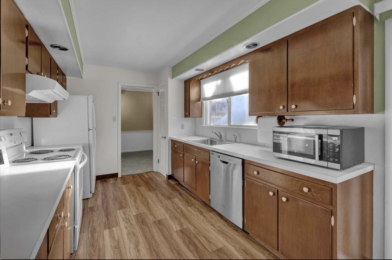 Before: the kitchen looking toward the doorway, with a white coil range